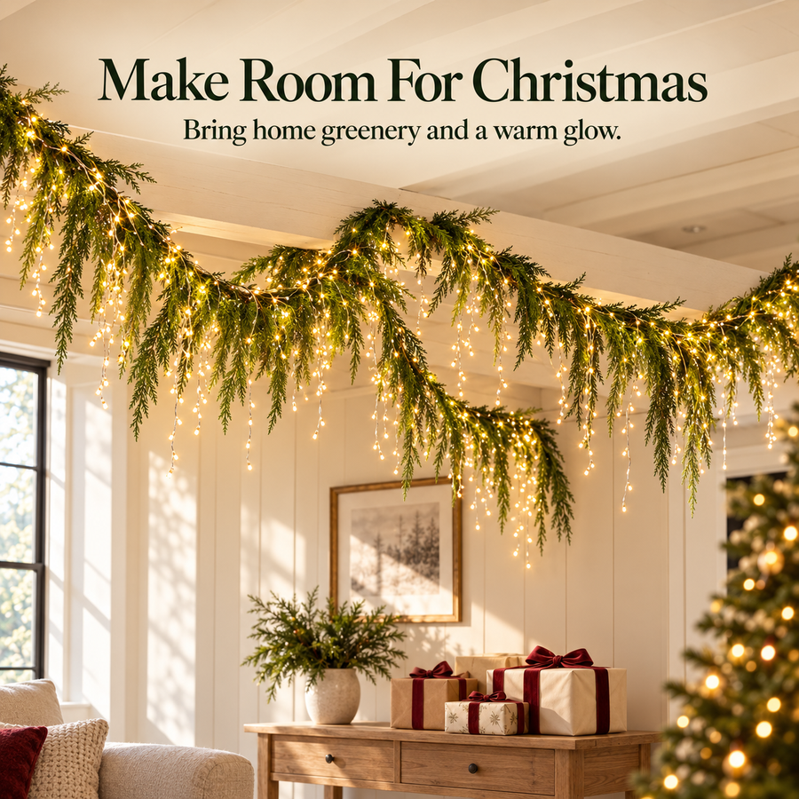 Evergreen garland and warm cascading lights above a Christmas display