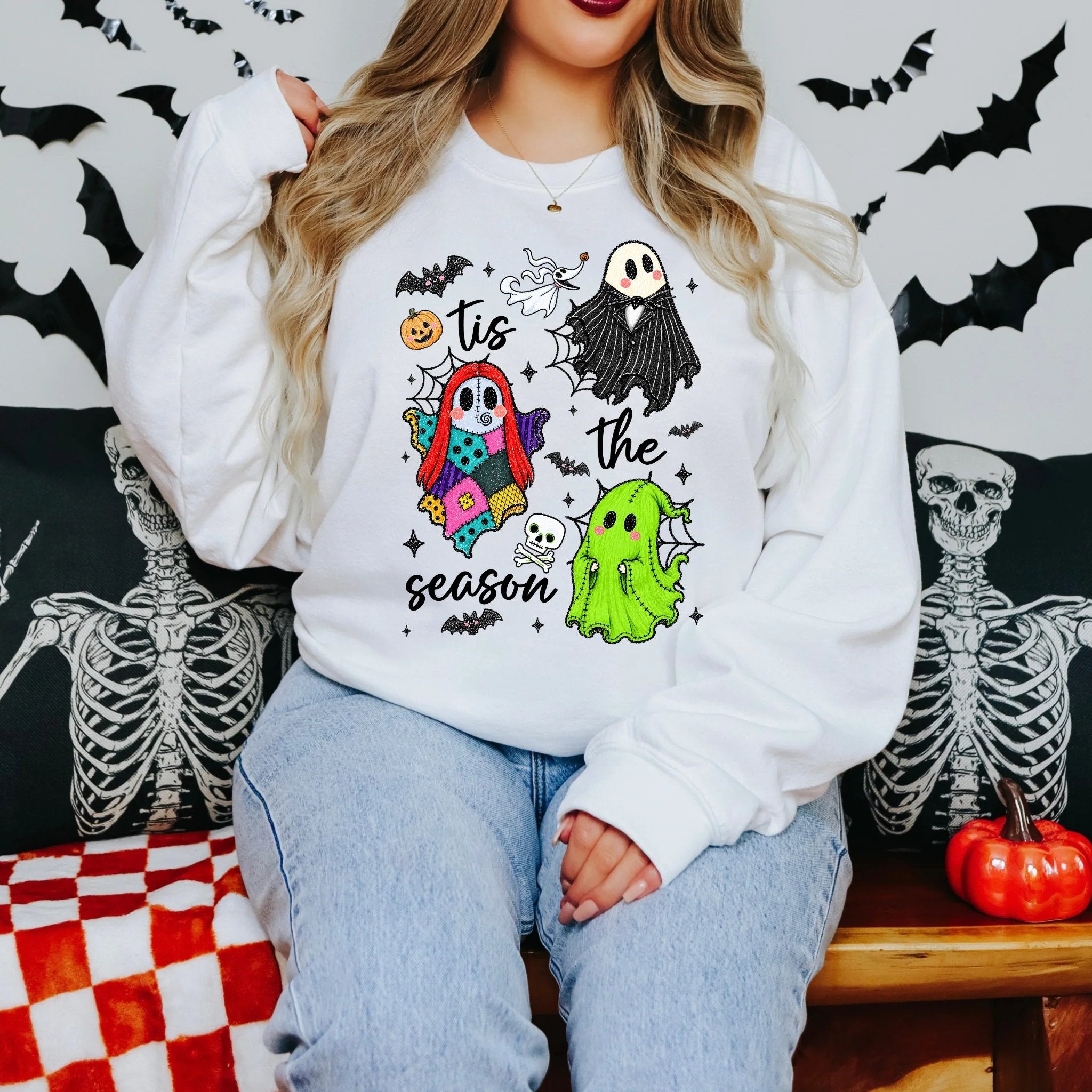 Lifestyle styling example of a woman wearing a white sweatshirt with colorful Halloween ghost artwork
